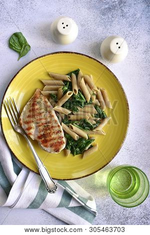 Whole Wheat Penne Pasta With Spinach And Grilled Chicken Breast.top View With Copy Space.