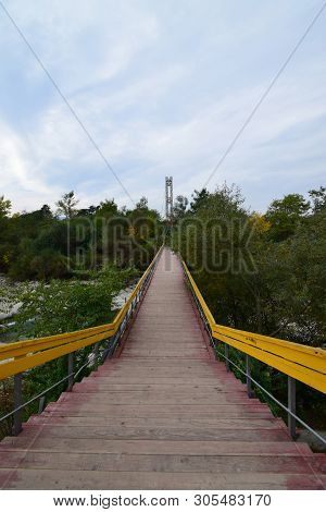 Mountain Bridge Over The River With Yellow Railings On The Mountain Kizilovka In The Foothills Of Th