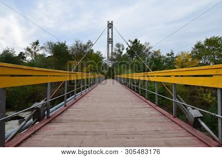 View Of The Suspension Bridge With Yellow Railings And Taut Cables Across The River On Mount Kizilov