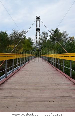 View Of The Suspension Bridge With Yellow Railings And Taut Cables Across The River On Mount Kizilov