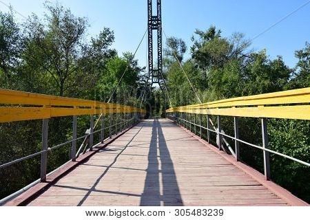 Mountain Suspension Bridge With Yellow Railings And Cables On Mount Kizilovka In The Foothills Of Th