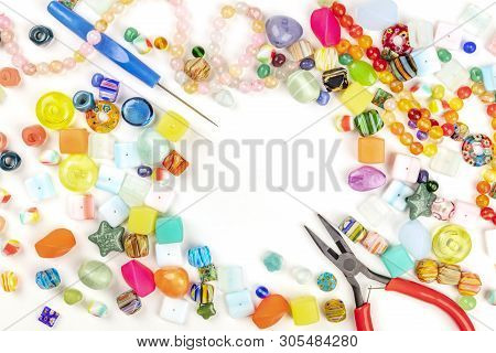 Many Different Beads With Tools For Making Jewellery, Shot From The Top On A White Background With A