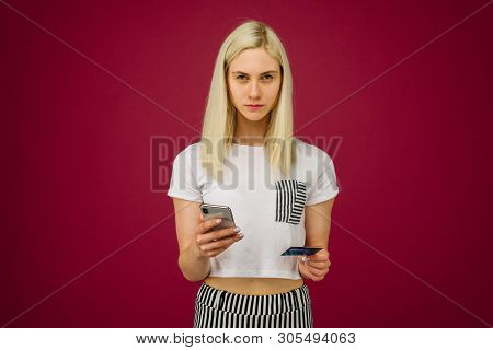 A Young Woman Holds A Smartphone And A Credit Card In Her Hands. Problems With A Bank Card, Because 