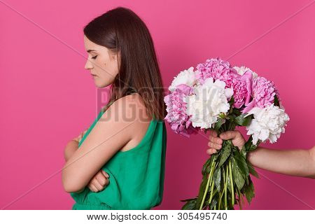 Beautiful Girl Stands Backwards To Unknown Faceless Person Who Give Her Peonies Isolated Over Yellow