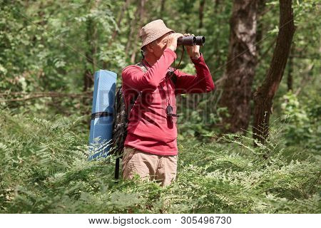Profile Of Active Hicker Looking Through Binoculars, Having Compass On His Neck, Wearing Sweatshirt 