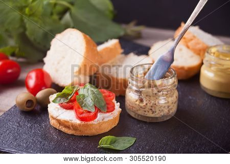 Italian Bruschetta With Cream Cheese, Tomato Cherry And Bazil And Cutting Bread On The Plate With Sm
