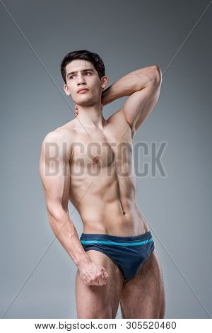 Young Male Athlete Bodybuilder Posing. Handsome Athletic Male Power Guy. Fitness Muscular Person. Yo