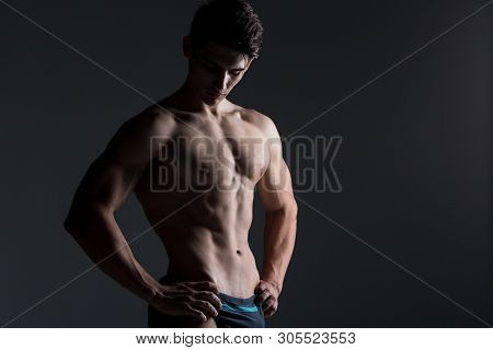 Young Male Athlete Bodybuilder Posing. Handsome Athletic Male Power Guy. Fitness Muscular Person. Yo