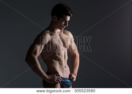 Young Male Athlete Bodybuilder Posing. Handsome Athletic Male Power Guy. Fitness Muscular Person. Yo