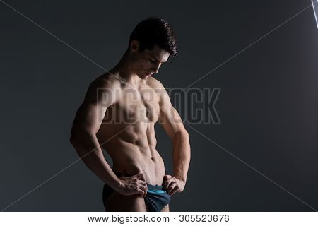 Young Male Athlete Bodybuilder Posing. Handsome Athletic Male Power Guy. Fitness Muscular Person. Yo