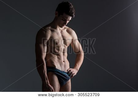 Young Male Athlete Bodybuilder Posing. Handsome Athletic Male Power Guy. Fitness Muscular Person. Yo