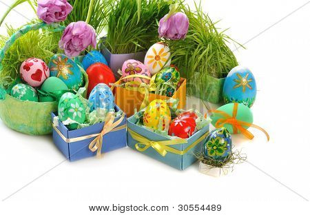 ทาสีไข่อีสเตอร์กับหญ้าและดอกทิวลิปบนพื้นหลังสีขาว