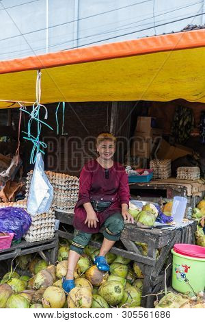 Makassar, Sulawesi, Indonesia - February 28, 2019:  Terong Street Market. Smiling Female Coconust Ve