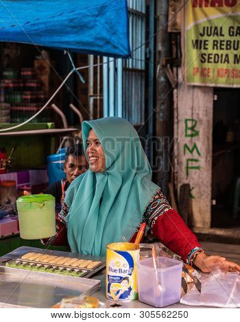 Makassar, Sulawesi, Indonesia - February 28, 2019: Terong Street Market. Smiling Female Fast Food Ve