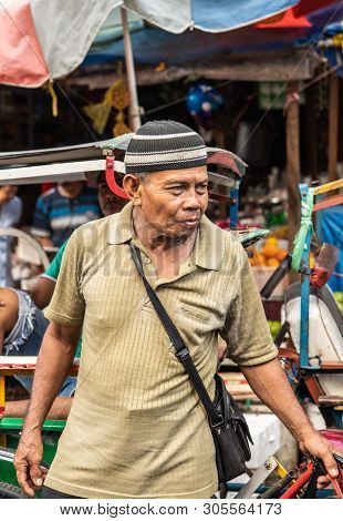 Makassar, Sulawesi, Indonesia - February 28, 2019: Terong Street Market. Closeup Portrait Of Older M