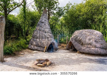 Old Thatch, Straw Celtic Cottage With Camp Fire, Concept Of Early Age Human Settlement, Green Forest