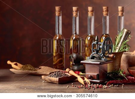 Vintage Pepper Mill With Various Peppers And Spices. Old Pepper Mill With Cooking Utensils, Bottles 