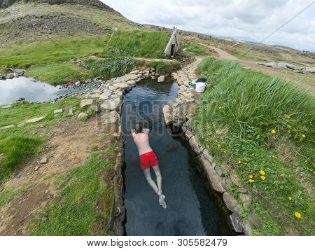 Man Relaxing In A Hot Spring Pool In Hrunalaug, Iceland