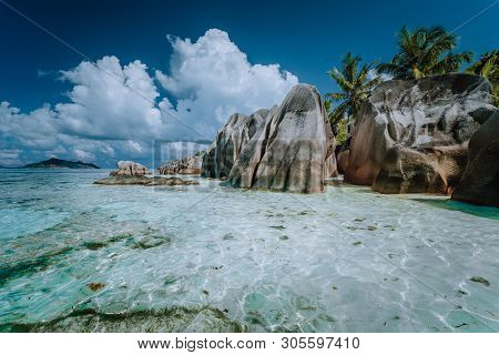 Granite Boulders In Shallow Ocean Water And White Cloudscape On Amazing Anse Source Dargent Tropical