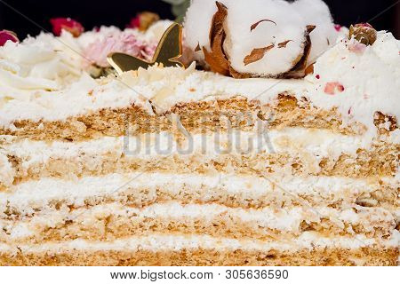 Half A Cake. Close-up Of A Cut Cake With Visible Layers And Filling. Onditer Holds The Cake In His H
