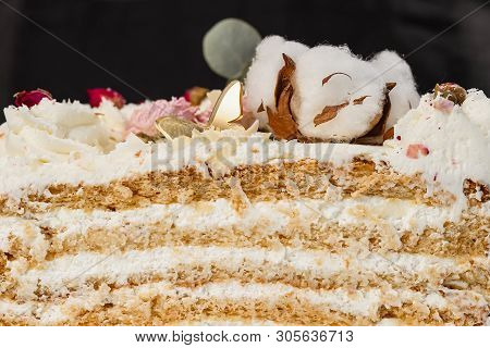 Half A Cake. Close-up Of A Cut Cake With Visible Layers And Filling. Onditer Holds The Cake In His H
