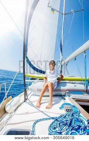 Little Boy On Board Of Sailing Yacht On Summer Cruise. Travel Adventure, Yachting With Child On Fami