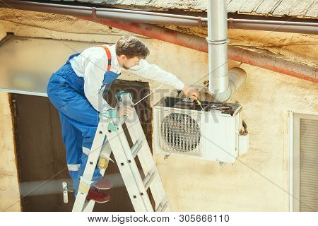 Hvac Technician Working On A Capacitor Part For Condensing Unit. Male Worker Or Repairman In Uniform