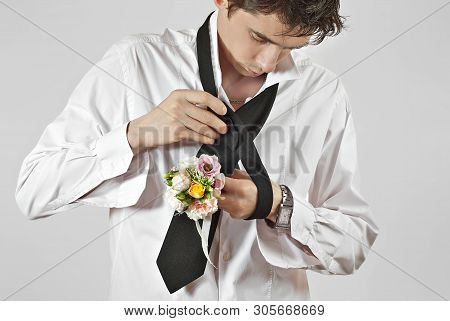 A Man Tied A Tie. Preparing For A Wedding Day. The Guy Is Learning To Tie The Knot For A Tie. Black 