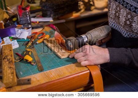 Professional Male Skinner, Tanner Working With Genuine Leather Belt At Workshop, Studio. Handmade An
