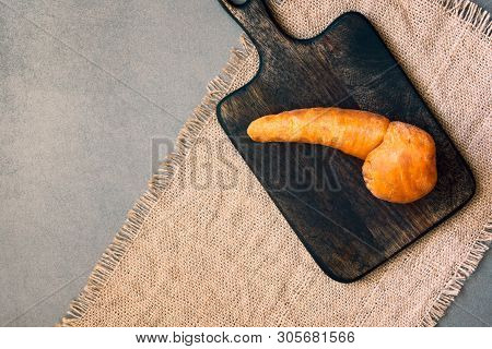 Ugly Food. Trendy Imperfect Carrot On Wooden Board. Misshapen Produce, Weird Fruits And Vegetables, 