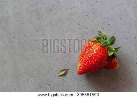 Ugly Strawberry. Strange Deformed Organic Fruit On Gray Cement Background. Misshapen Produce, Food W