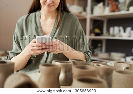 Mid Section Portrait Of Contemporary Artisn Using Smartphone While Working In Pottery Shoip, Copy Sp