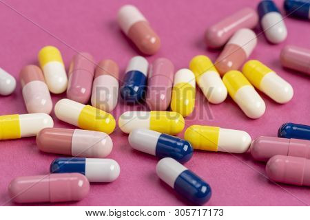 Medical Pills Yellow, Blue And Red On A Colored Background