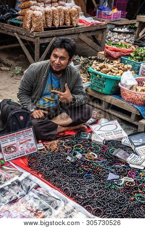 Makassar, Sulawesi, Indonesia - February 28, 2019: Terong Street Market. Man Sits On Ground Selling 