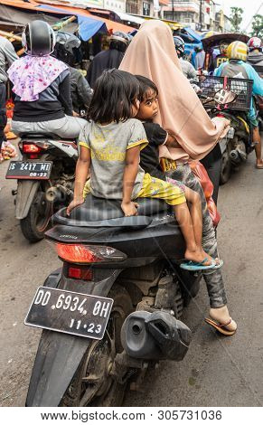 Makassar, Sulawesi, Indonesia - February 28, 2019: Terong Street Market. Two Little Girls Ride Behin