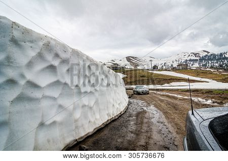 Goderdzi, Georgia - May 8, 2017. Bank Of Snow On Main Broken Dirt Road