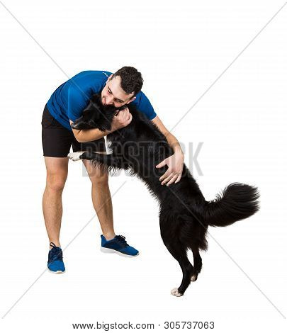 Full Length Portrait Of Happy Young Man Snuggling And Giving A Hug To His Obedient Lovely Border Col