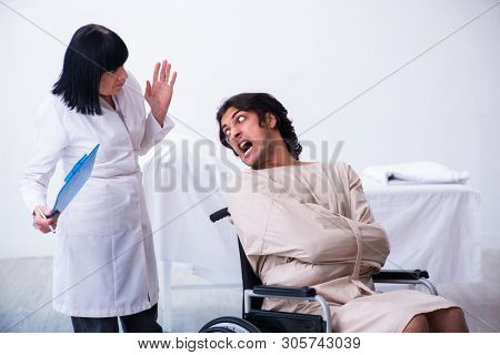 Old female psychiatrist visiting young male patient 