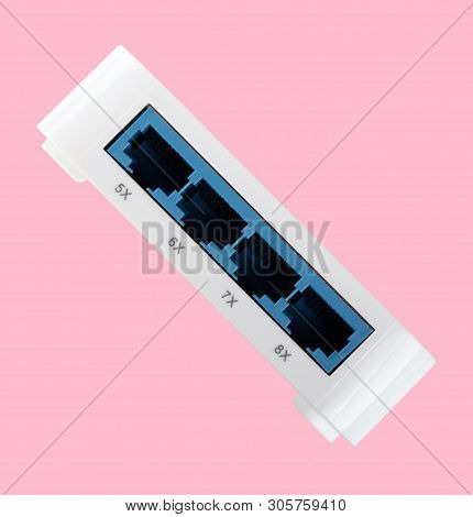 White 8 Port Plastic Ethernet Switch Isolated On Pink Background At Dry Day