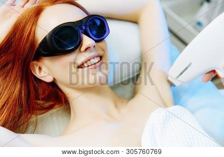 Body Care. Underarm Laser Hair Removal. Beautician Removing Hair Of Young Woman's Armpit.