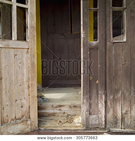 Entrance Of Gaunt Wooden House Seemingly Abandoned With Half Open Door