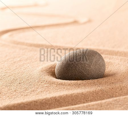 Spa wellness or mindfulness stone and sand garden. Concentration or focus point for spiritual balance and purity of mind and soul. Sandy background with copy space. 