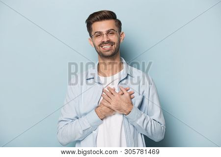 Grateful Guy In Glasses Put Hands On Chest Studio Shot