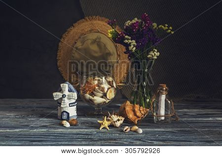 Still Life. A Variety Of Seashells, Wild Flowers (limonium Sinuatum) And Starfish On A Wooden Table 
