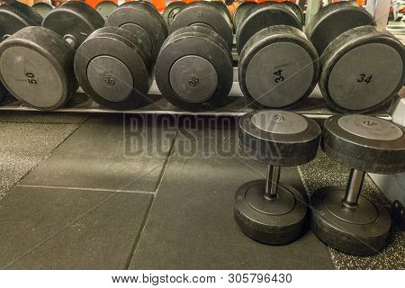 Rows Of Dumbbells In The Gym With Hign Contrast And Monochrome Color Tone.