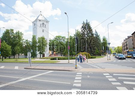 City Jelgava, Latvian Republic. City Urban Street And Peoples Standing By Traffic Light. Houses And