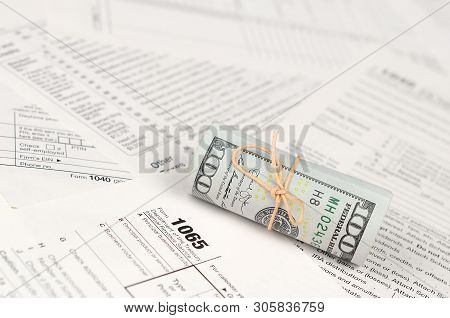 1065 U.s. Return Of Parentship Income Form With Roll Of American Dollar Banknotes