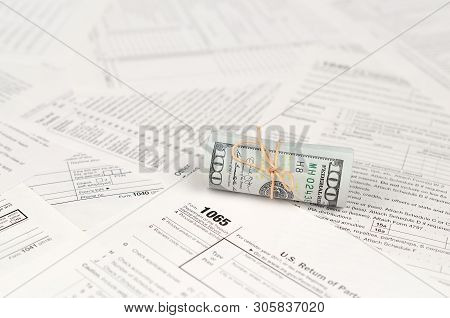 1065 U.s. Return Of Parentship Income Form With Roll Of American Dollar Banknotes