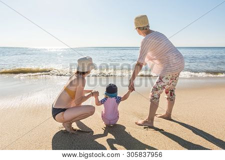 Three Generations Of A Family (grandmother, Daughter And Granddaughter) Holding Hands At The Beach I