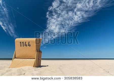 Lonely Beach Chair Near The Ocean Under Blue Sky